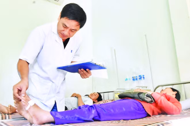 Thượng tá, bác sĩ chuyên khoa I Nguyễn Văn Tuấn, Trưởng Khoa điều trị rắn cắn khám bệnh cho bệnh nhân.
