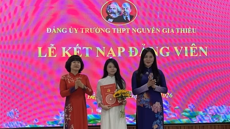 Bí thư Đảng ủy, Chủ tịch Hội đồng nhân dân phường Bồ Đề Vũ Thị Thành (người đứng bên trái) trao quyết định kết nạp Đảng cho học sinh trường Trung học phổ thông Nguyễn Gia Thiều.