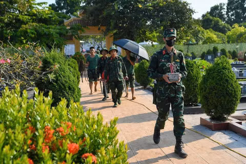 Hài cốt liệt sĩ được cán bộ, chiến sĩ đưa ra khu vực lấy mẫu ADN. (Ảnh: THẾ ĐẠI)