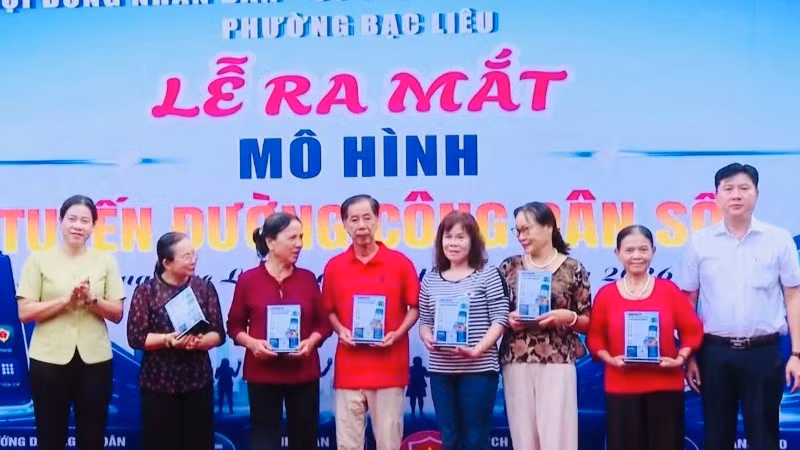 Đồng chí Lê Việt Thu, Thường vụ Tỉnh ủy Cà Mau, Bí thư Đảng ủy phường Bạc Liêu (bìa trái) cùng Chủ tịch Ủy ban nhân dân phường Lê Việt Xô trao tặng bảng mã QR cho các hộ dân đại diện trên tuyến đường Bà Huyện Thanh Quan.