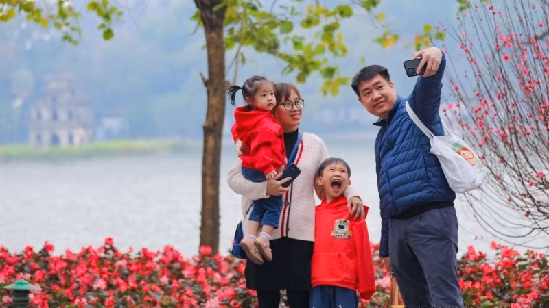 Cả gia đình cùng nhau ghi lại khoảnh khắc của mùa Xuân bên hồ Gươm. (Ảnh: Thanh Tùng/TTXVN)