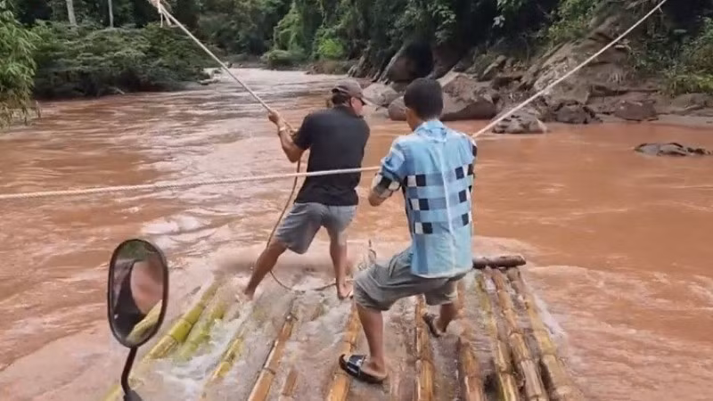 Để giữ bè không trôi theo dòng nước, người dân phải dùng sức bám chặt vào dây thừng dòng dọc ngang suối. 