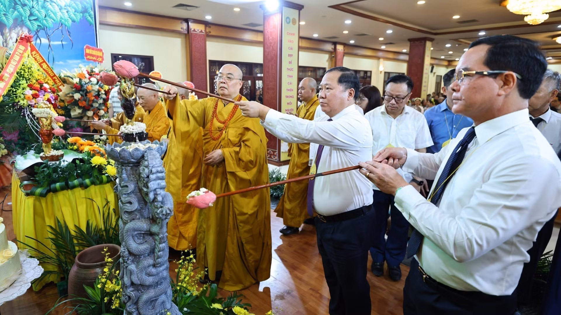 Các đại biểu và Phật tử thực hiện nghi thức tắm Phật. (Ảnh: Minh Đức/TTXVN)