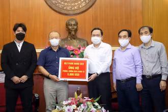 Đồng chí Trần Thanh Mẫn tiếp nhận ủng hộ từ HLV Park Hang Seo. Ảnh: Kỳ Anh.