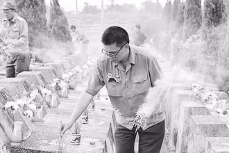 Cựu chiến binh Nguyễn Đình Thắng thắp hương cho đồng đội cũ ở Nghĩa trang Vị Xuyên.