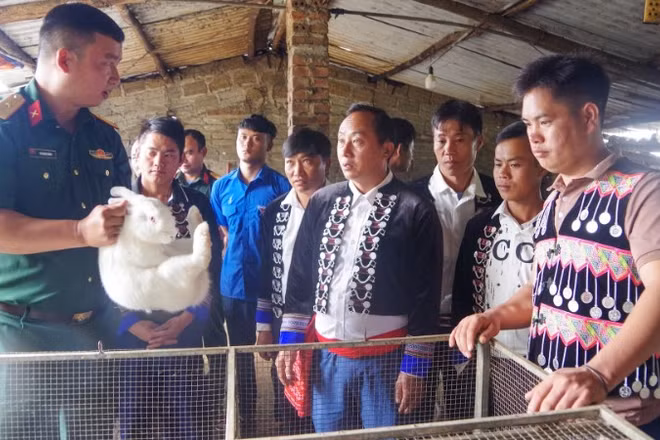 Thiếu tá Nguyễn Mạnh Hùng, Đội trưởng Sản xuất và Xây dựng cơ sở chính trị số 3 hướng dẫn người dân bản Sín Chải, xã Dào San kỹ thuật nuôi thỏ.