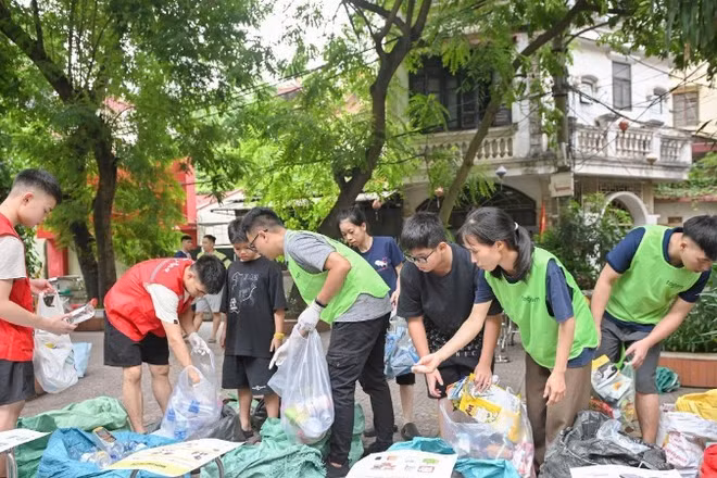 Các thành viên nhóm Tagom ở Hà Nội hướng dẫn người dân cách phân loại rác. (Ảnh: THẾ ĐẠI)