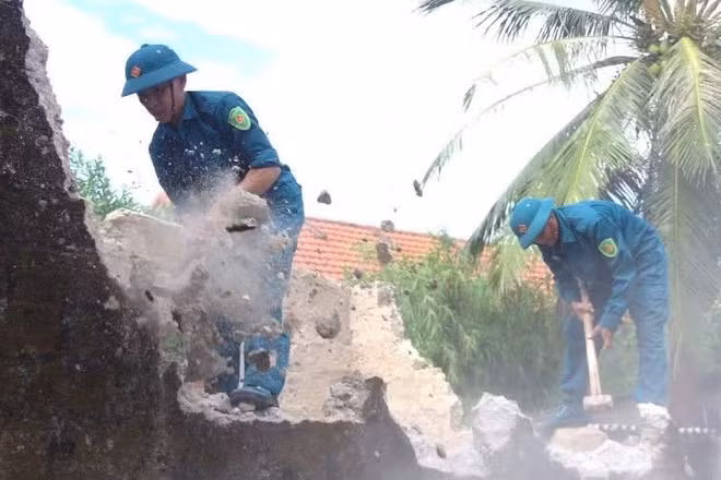 Lực lượng dân quân xã Ninh Châu (Quảng Trị) tham gia hỗ trợ phá dỡ nhà cũ đến xây nhà mới cho gia đình nạn nhân chất độc hóa học. (Ảnh nhandan.vn)