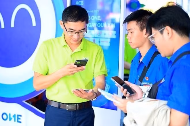 Nhân viên Ngân hàng ACB giới thiệu với khách hàng các tiện ích thanh toán số. (Ảnh ACB)