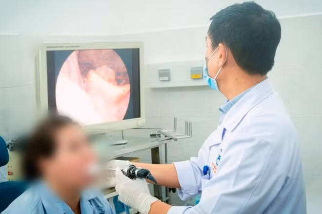 Bác sĩ nội soi thanh quản cho người bệnh sau thời gian điều trị.