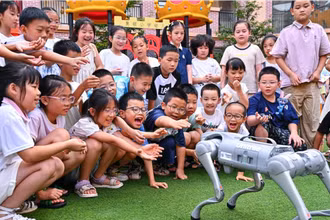 Trẻ em “giao lưu” với chó robot ở huyện Nhân Thọ, thành phố My Sơn, tỉnh Tứ Xuyên, Trung Quốc. (Ảnh: Tân Hoa Xã)
