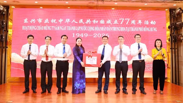 Đồng chí Nguyễn Thị Hiền, Bí thư Đảng ủy phường Móng Cái 1 chúc mừng chính quyền thành phố Đông Hưng nhân dịp kỷ niệm 77 năm Quốc khánh Trung Quốc. (Ảnh: QUANG THỌ)