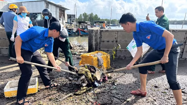 Đoàn viên thanh niên giúp người dân dọn bùn đất sau bão.
