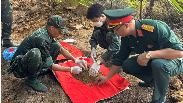 Lực lượng chức năng tiến hành khai quật, cất bốc các hài cốt liệt sĩ. (Ảnh: THANH SƠN)
