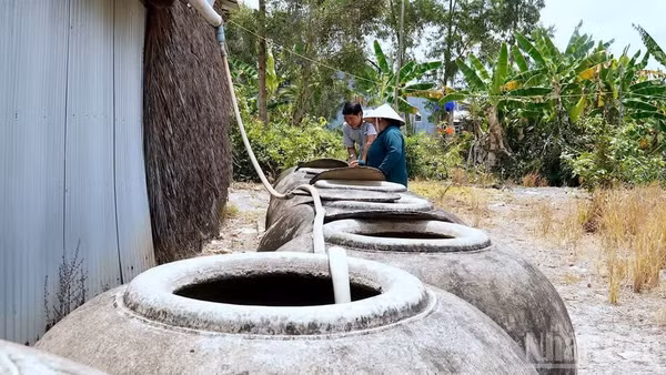 Người dân vùng nông thôn Cà Mau dùng lu to trữ nước mưa sử dụng cho sinh hoạt trong mùa khô. (Ảnh: HỮU TÙNG) 