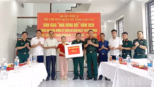 Đại tá Nhữ Đình Khoe, Chủ nhiệm Chính trị Bộ Chỉ huy Quân sự tỉnh Lào Cai trao quà tặng gia đình Đại úy Đỗ Quang Vinh. (Ảnh: THANH SƠN)