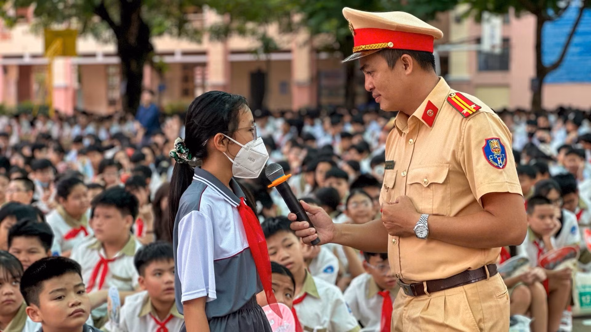 Cán bộ Phòng Cảnh sát giao thông, Thành phố Hồ Chí Minh trao đổi với một học sinh về an toàn giao thông. 