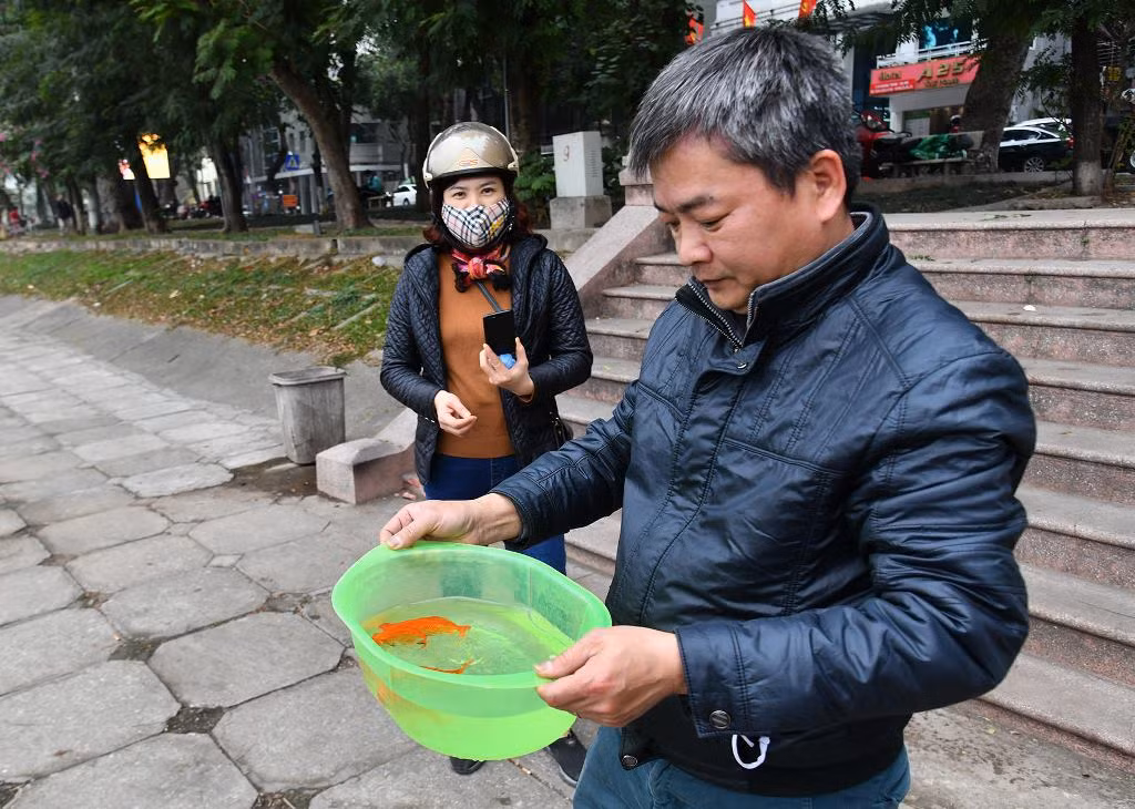 Người dân Hà Nội thả cá chép tiễn ông Táo về trời -0