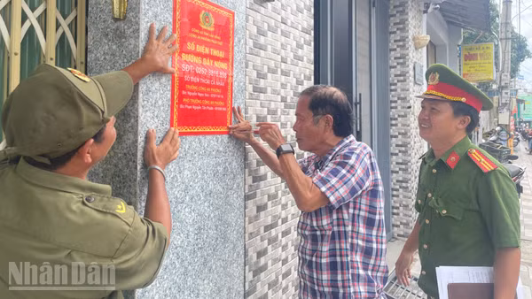 Công an phường Phan Thiết gắn bảng thông tin đường dây nóng khu vực dân cư. (Ảnh: THANH HẢI)
