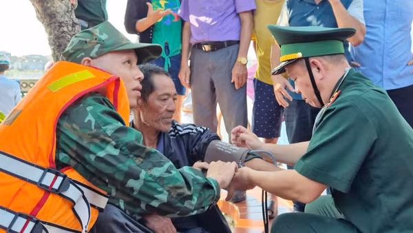 Quân y Đồn Biên phòng Lý Hòa kiểm tra sức khỏe cho ngư dân Nguyễn Tiến Châu khi vừa được tàu cá Quảng Bình cứu nạn đưa vào bờ. (Ảnh: HN)