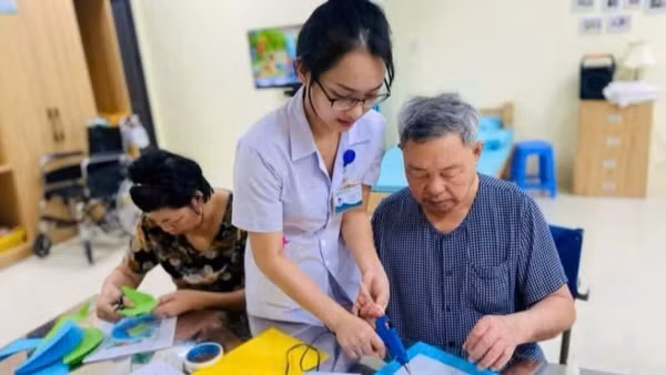 Nhân viên y tế hỗ trợ người cao tuổi phục hồi chức năng tại Trung tâm chăm sóc sức khỏe người cao tuổi Đà Nẵng. (Ảnh ST)