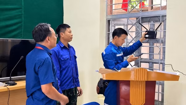 Công nhân đơn vị viễn thông lắp đặt bộ phát wi-fi tại Nhà Văn hóa bản Mường, xã Mường Mùn, tỉnh Điện Biên. (Ảnh: MƯỜNG MÙN)