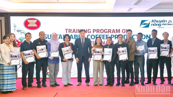 Giám đốc Trung tâm Khuyến nông quốc gia Lê Quốc Thanh trao chứng nhận và ảnh lưu niệm cho các học viên tham gia lớp tập huấn. (Ảnh: BẢO VĂN)