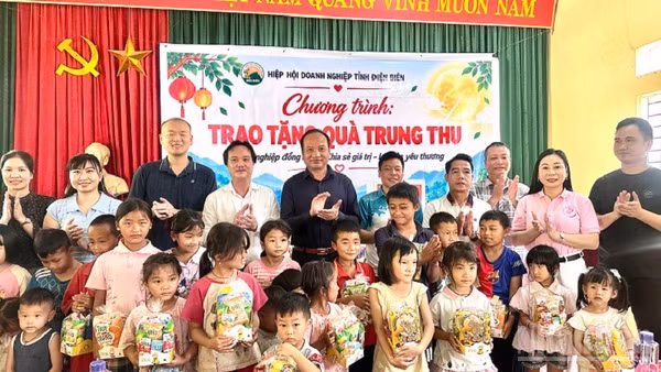 Ông Nguyễn Chí Ba, Phó Chủ tịch Hiệp hội Doanh nghiệp tỉnh Điện Biên cùng các doanh nghiệp thành viên Hiệp hội trao quà trung thu tặng các cháu học sinh bản Đề Chia, xã Pú Nhung. Ảnh: LÊ LAN