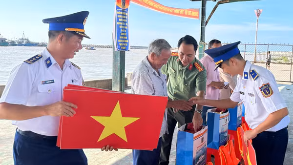 Lực lượng chức năng trao cờ, tặng quà cho ngư dân tỉnh Lâm Đồng. (ẢNH: KIỀU KIỀU)