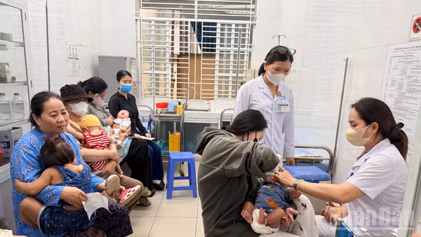 Phụ huynh đưa trẻ đi tiêm chủng tại Trạm y tế phường Phan Thiết.