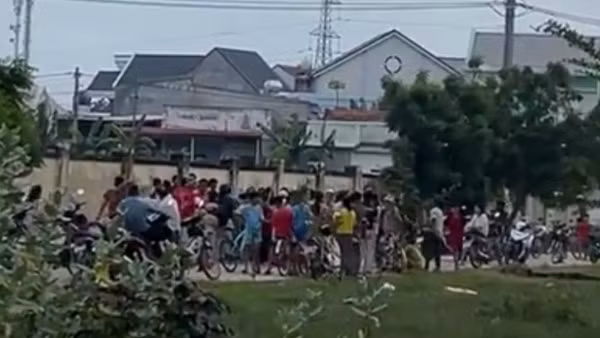 Người dân hiếu kỳ đứng tại nhà nạn nhân. (ẢNH: QUÝ NGỌC)