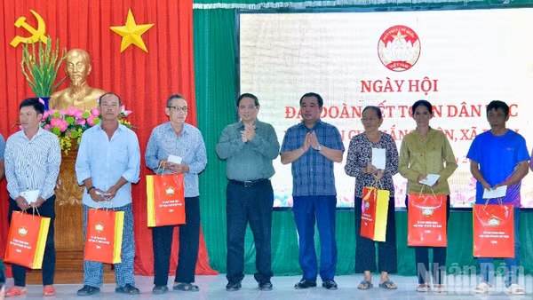 Thủ tướng Phạm Minh Chính tặng quà các hộ dân ở khu dân cư Thắng Kiên, xã Đề Gi, nhân Ngày hội Đại đoàn kết toàn dân tộc. (Ảnh: THANH GIANG)