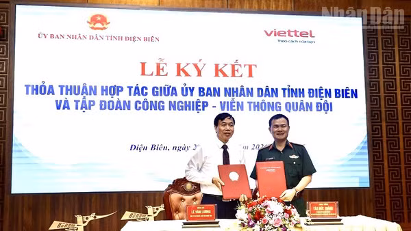Đồng chí Lê Văn Lương, Chủ tịch Ủy ban nhân dân tỉnh Điện Biên và Trung tướng Tào Đức Thắng, Ủy viên Trung ương Đảng, Chủ tịch kiêm Tổng Giám đốc Tập đoàn Công nghiệp-Viễn thông Quân đội trao biên bản ký kết thỏa thuận hợp tác. (Ảnh: LÊ LAN)