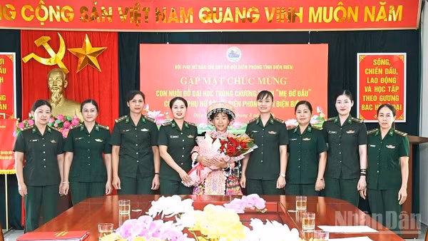 Các mẹ đỡ đầu ở Ban Chỉ huy Bộ đội Biên phòng tỉnh Điện Biên tặng hoa, chúc mừng cháu Sùng Thị Khoa. (Ảnh: LÊ LAN)