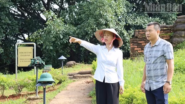Giám đốc Bảo tàng Điện Biên Phủ Vũ Thị Tuyết Nga kiểm tra việc tu sửa, chỉnh trang cây xanh, vườn hoa tại các điểm di tích thuộc quần thể di tích chiến trường Điện Biên Phủ. (Ảnh: Lê Lan)