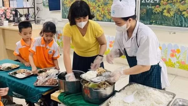 Chia suất ăn bán trú cho học sinh tại trường Tiểu học Văn Yên (Hà Nội). (Ảnh: NGUYÊN TRANG)