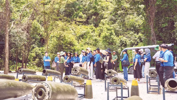 Du khách tham quan khu trưng bày chứng tích bom mìn ngoài trời tại Hang Chỉ Huy.
