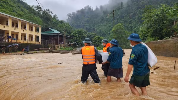 Cán bộ, chiến sĩ Đồn Biên phòng Tam Hợp và Ban Chỉ huy quân sự xã Tam Thái, tỉnh Nghệ An, đưa cơm cho học sinh điểm trường bán trú bị mưa lũ chia cắt. (Ảnh: TRUNG HIẾU)