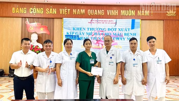 Lãnh đạo Trung tâm Y tế Tuần Giáo trao thưởng, động viên thành viên kíp trực đã phẫu thuật, cấp cứu và hiến máu cứu bệnh nhân qua cơn nguy kịch. (Ảnh: LÊ LAN)
