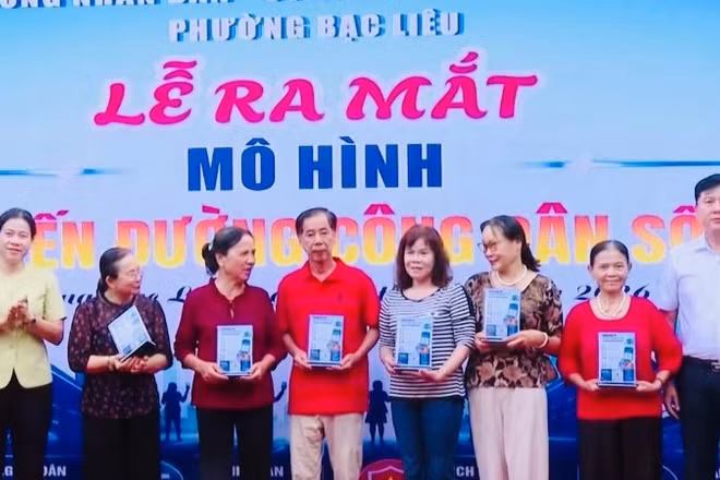 Đồng chí Lê Việt Thu, Thường vụ Tỉnh ủy Cà Mau, Bí thư Đảng ủy phường Bạc Liêu (bìa trái) cùng Chủ tịch Ủy ban nhân dân phường Lê Việt Xô trao tặng bảng mã QR cho các hộ dân đại diện trên tuyến đường Bà Huyện Thanh Quan.
