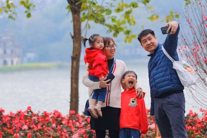 Cả gia đình cùng nhau ghi lại khoảnh khắc của mùa Xuân bên hồ Gươm. (Ảnh: Thanh Tùng/TTXVN)