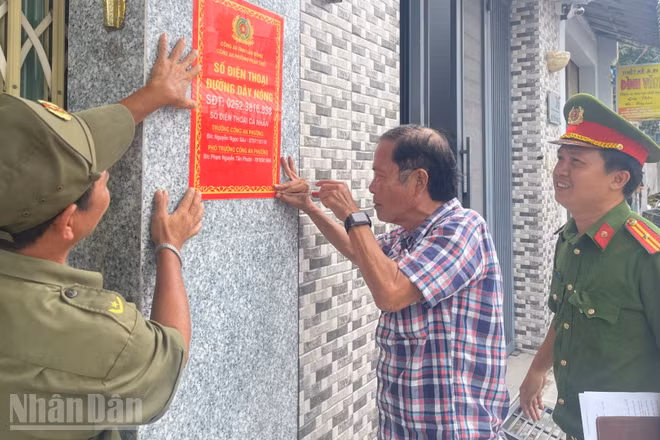 Công an phường Phan Thiết gắn bảng thông tin đường dây nóng khu vực dân cư. (Ảnh: THANH HẢI)