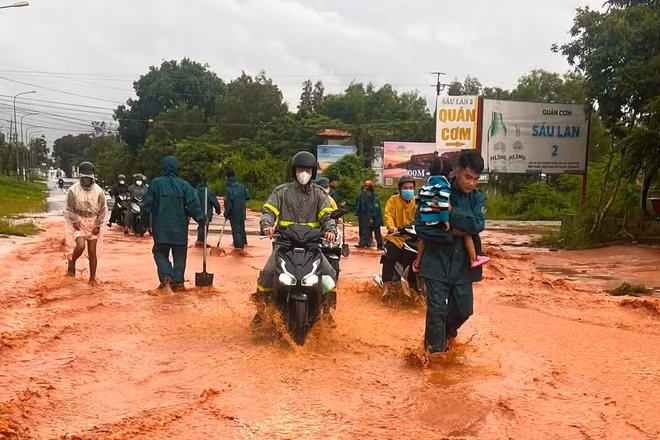 Lực lượng chức năng hỗ trợ người dân qua đường. Ảnh: (NGUYỄN LỆNH)