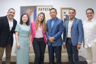 Đại sứ Vũ Trung Mỹ (thứ 3 từ phải qua) và Chủ tịch TELESUR Patricia Villegas (áo hồng) cùng lãnh đạo TELESUR chụp ảnh kỷ niệm. (Ảnh: Đại sứ quán Việt Nam tại Venezuela)