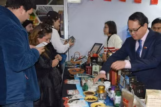 Đại sứ Việt Nam tại Chile Nguyễn Việt Cường giới thiệu các sản phẩm cà-phê của Việt Nam với khách tham quan Hội chợ. (Ảnh: Đại sứ quán Việt Nam tại Chile)