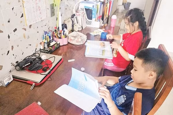 Em Nguyễn Hoàng Trâm Anh (áo đỏ) cùng bạn đang tìm hiểu sách giáo khoa mới.