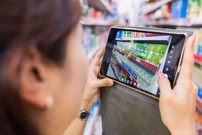 Nhân viên kinh doanh chụp ảnh khu vực trưng bày và tải lên hệ thống DMS của Vinasoy. (Ảnh: AWS)