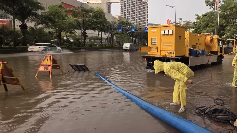 Nhân viên Công ty Thoát nước Hà Nội ứng trực tại điểm "dềnh nước" trên đường Võ Chí Công. (Nguồn: TTXVN)