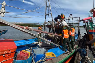Cán bộ, chiến sĩ Đồn Biên phòng Diễn Thành hướng dẫn, giúp đỡ ngư dân neo đậu tàu thuyền phòng, chống bão số 5. (Ảnh: nhandan.vn) 