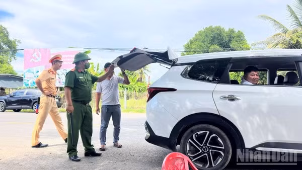 Lực lượng chức năng kiểm tra phương tiện ra vào xã Diên Lâm tại chốt cầu Phú Cốc. (Ảnh: VŨ TÂN)